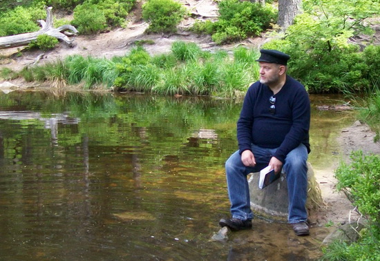 Manfred G. Bauer l&auml;sst sich auf dem Sitzstein Merlines am Ufer de Wildsees nieder. Hoffen wir, dass ihm dies die Nixe nicht &uuml;bel nimmt.